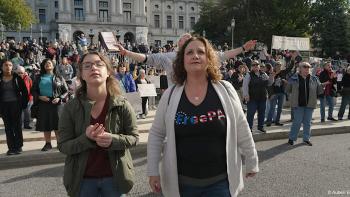 An American Pastoral movie: Tina Wilson and friend stands in front smiling at a pro-life rally