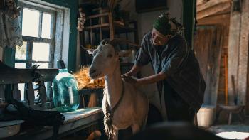 Animals in War: A Ukranian old woman pets a goat inside of her home