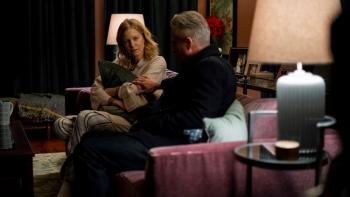 The Apology Movie: Darlene (Anna Gunn), wearing a bathrobe and clutching a pillow, sits on a couch facing Jack (Linus Roache), whose back is to the camera