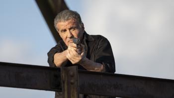 Armor Movie: On a bridge, Rook (Sylvester Stallone) points a gun at something
