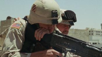 Atonement movie: Soldier (Boyd Holbrook) fires an assault rifle at a target below, encouraged by his sergeant