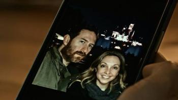 A Toxic Love Story: A couple smiles in a smartphone photo, city lights in the background.