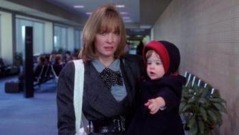 Baby Boom: Diane Keaton looks unhappy holding a baby in an airport.