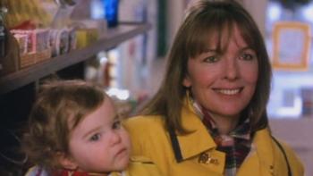 Baby Boom: Diane Keaton smiles holding a baby in a shop.