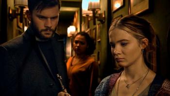 Baghead: Two young women and a man stand in a dimly-lit hallway, looking tense and focused