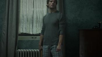 Bagman Movie: Pat (Sam Claflin), carrying a baseball bat, looks around the house at night