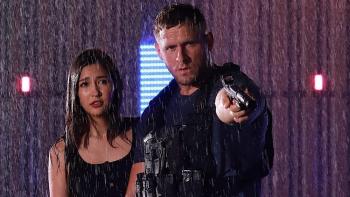 Bang 2025 movie: Jack Kesy stands next to Marie Broenner in the rain while pointing his gun