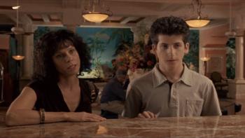 Bart Got a Room: Two people standing at a hotel desk, woman on the left, young man on the right, both attentive