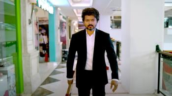 Beast: A middle-aged bearded Indian man in a suit walks toward camera in a mall