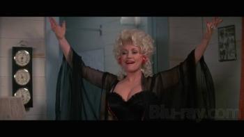  The Best Little Whorehouse in Texas: Dolly Parton with open arms, wearing a sheer black robe, smiling.