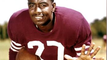 Because They Believed: Football legend R. C. Owens poses in uniform with one arm held in front of him and the other clutching a football