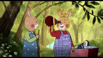 Two animated rabbits stand in a forest looking through a birthday hat.