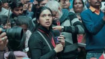 Bhakshak scene 2: Indian woman with microphone surrounded by crowd