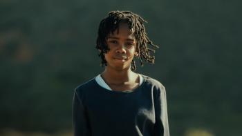 Bird Boy movie: An African boy stands outside with a deflated look on his face