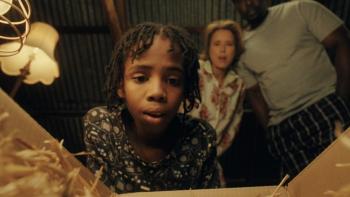 Bird Boy movie: Three people stand over a box with a hatching egg inside