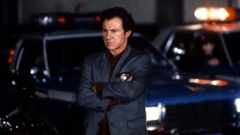 Bad Lieutenant: Harvey Keitel leans against a police car with his arms crossed