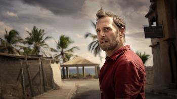 The Black Demon Movie: Oil company inspector Paul Sturges (Josh Lucas), standing in a run-down beachside resort town, looks warily over his shoulder