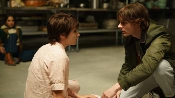 Black Phone 2 Movie: On the floor of a kitchen, Gwen seems disoriented as Finney kneels to check on her