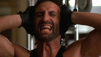 Blue Steel: A White, bearded man makes an anguished expression as he holds his hands to his ears while shirtless