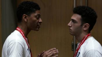 Boys State Movie: Two boys wearing Texas Boys State lanyards appear to be arguing -- one Black teen, one White teen