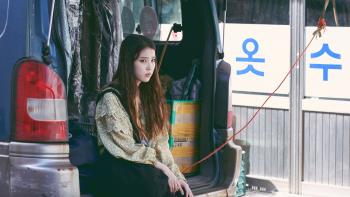 Broker: A sad looking young Asian woman sits in the back of an open van