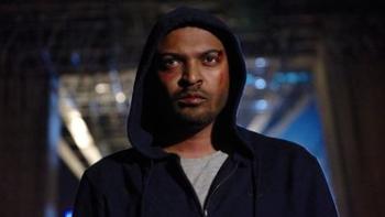 Brotherhood: A young Black Man walks through the dark city streets wearing a hoodie and with bruises on his face