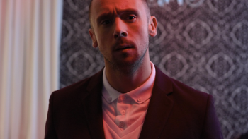 Brotherhood: A young White man looks serious wearing a suit inside a fancy London home