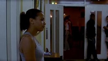 Bullet Boy: Sharea Samuels stands against a wall wearing a white top with other characters in the background