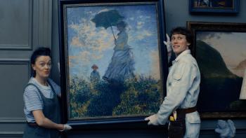 The End: A White woman and man hold a painting
