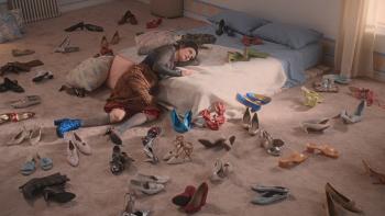 By Design Movie: Camille is slumped at the bottom of her mattress, many pairs of shoes scattered around her