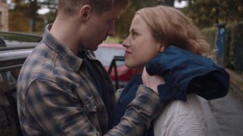 Calibre: A White man holding is pregnant partner with a car in the background