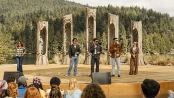 Camp Rock 3 Movie: Connie Torres stands on an outdoor stage with Connect 3 and their agent; teens watch from the audience.