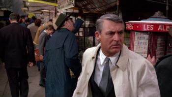 Charade: Cary Grant looks serious as he rushes through a market