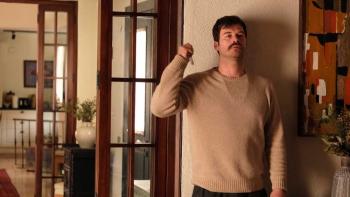 Chokehold: A Turkish man in beige tan sweater right stands with back against wall and with knife in right raised hand ready to strike