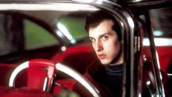 Christine Movie: Arnie (Keith Gordon) sits behind the wheel of Christine, a dark look on his face