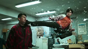 City Hunter movie: Japanese man in red shirt right bursts through window, jump kicks man in head on left