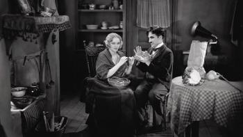 City Lights Movie: Charlie Chaplin helps a woman hold her yarn