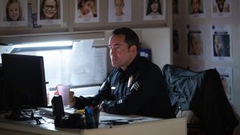 City of Dreams Movie: Police officer Stevens (Jason Patric) sits at his desk surrounded by missing-child fliers
