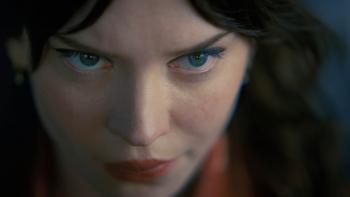 Companion Movie: Iris (Sophie Thatcher), her head tilted slightly down, eyes looking forward, wears a fierce expression