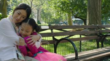 Confetti Movie: Lan Chen and Meimei cuddle together on a park bench