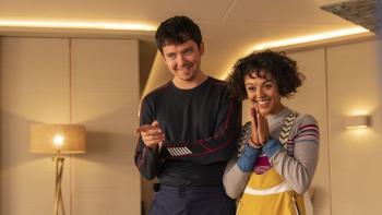 Your Christmas or Mine 2: A young White man and a young biracial woman smile and point toward someone out of shot.