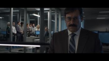 Corner Office Movie: Jon Hamm looks dejected sitting at his desk, while in the background, nine of his coworkers look at him