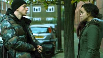 County Lines: A young man and a mother stand facing each other in the street, looking serious