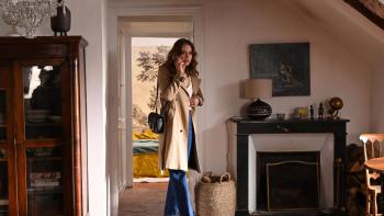 Coup de Chance Movie: Looking concerned, Fanny speaks on the phone while searching Alain's deserted apartment