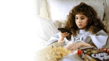 Curly Sue Movie: Curly Sue watching TV, holding remote, surrounded by snacks on a bed.