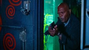 Damaged Movie: Samuel L. Jackson comes through a door, looking serious and holding a gun