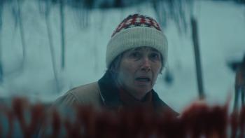 Dead of Winter movie: Emma Thompson, wearing a knit cap, looks distressed while standing outside a blood-splattered back windshield