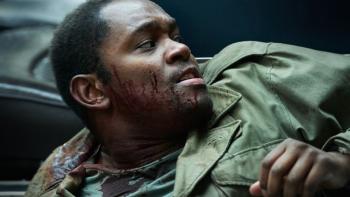Dead Shot: A young Black man in army uniform with blood on his face looks to the right