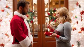 Dear Christmas: Jason Priestley stands dressed as Santa on the left, with Melissa Joan Hart opening a gift opposite him on the right