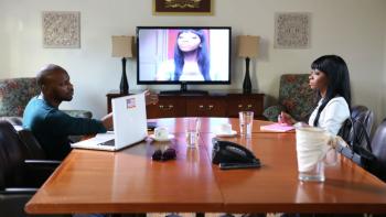 Dear White People movie: Two Black adults sit across from each other at a conference table